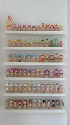 there are many small toy figures on the shelves in this room, all lined up