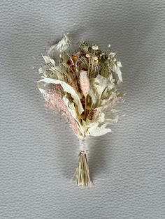 a bunch of dried flowers sitting on top of a white tablecloth covered floor next to a gray wall