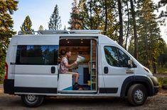 a man sitting in the open door of a van