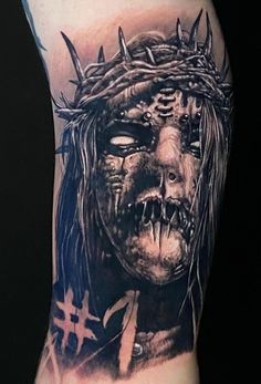 a man's arm with a tattoo on it that has a face and spikes