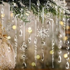 christmas decorations hanging from a tree in front of a window with snowflakes on it