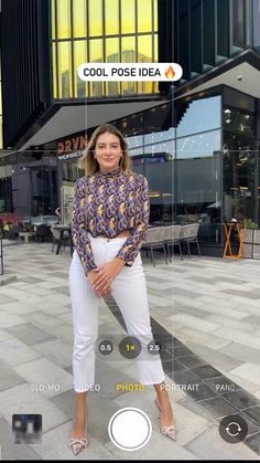 a woman standing in front of a building with her hands on her hips and looking at the camera