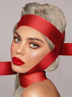 a woman with grey hair wearing red ribbon around her neck