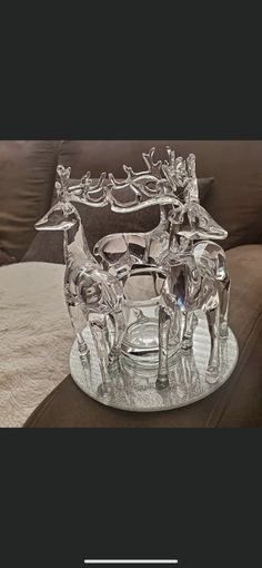 a glass sleigh with reindeers on it sitting on a table in front of a couch