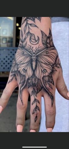 a person's hand with a butterfly tattoo on it