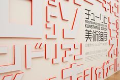 the wall is decorated with red and white letters, which are arranged in different shapes