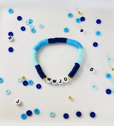 "A blue WWJD Heishi bracelet is a stylish and meaningful accessory that showcases a vibrant blue color. The bracelet features tiny disc-shaped beads made from various materials, such as wood, clay, or metal, arranged in a pattern. The acronym \"WWJD\" stands for \"What Would Jesus Do,\" serving as a constant reminder to live according to Christian values and seek guidance in daily life. This bracelet is a beautiful and subtle way to express faith and devotion, while also adding a touch of fashionable flair to any outfit." Blue Wooden Beads Stretch Bracelet As Gift, Blue Round Beads Friendship Bracelet, Blue Round Beads Friendship Bracelets, Casual Blue Name Bracelet For Everyday, Blue Casual Name Bracelet For Friendship, Personalized Blue Bracelets For Everyday Wear, Blue Beaded Bracelets For Friendship, Blue Beaded Friendship Bracelets, Blue Heishi Beads Stretch Bracelet With Colorful Beads