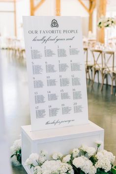 a wedding seating chart is placed on top of a table with flowers and greenery