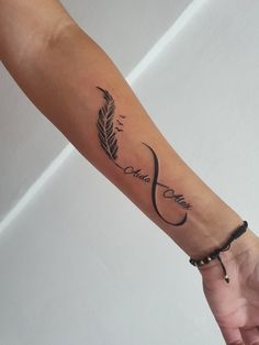 a woman's arm with a feather tattoo on it