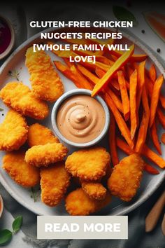 chicken nuggets are served on a plate with sweet potato fries and dipping sauce