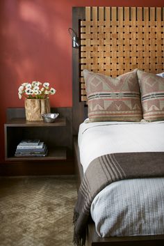 a bedroom with red walls and a bed in the center, two nightstands on either side