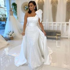 a woman in a white dress is standing on the floor wearing a tiara and gown