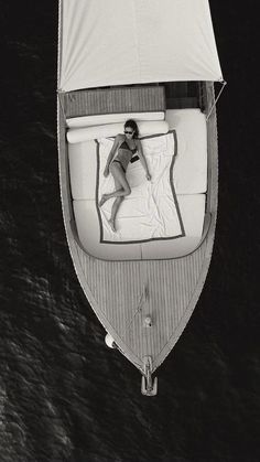 a woman laying on top of a bed in a boat