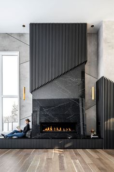 a woman sitting on the floor in front of a fire place with her feet up