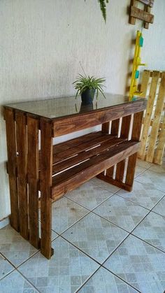 a wooden bench sitting on top of a tiled floor next to a potted plant