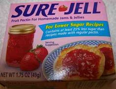 a box of pure jell sitting on top of a wooden table next to some strawberries