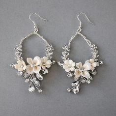 These hand-beaded hoop dangles feature porcelain bisque flowers, crystal stones, and silver lined seed beads. This style matches several of our pretty headpieces. They measure about 2.5 inches long and 2 inches wide on a hook style earring. Beaded Dangle Flower Earrings For Wedding, Wedding Beaded Dangle Flower Earrings, Jeweled Beaded Dangle Earrings For Wedding, Jeweled Dangle Beaded Earrings For Wedding, Bohemian Beaded Flower Earrings For Wedding, White Flower-shaped Jewelry With Dangling Beads, Adjustable White Hoop Earrings For Wedding, White Beaded Hoop Earrings For Wedding, Nickel-free White Crystal Earrings For Wedding