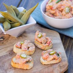 small appetizers are sitting on a cutting board next to a bowl of green beans