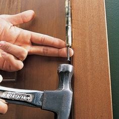 a person is holding a hammer and trying to open the door