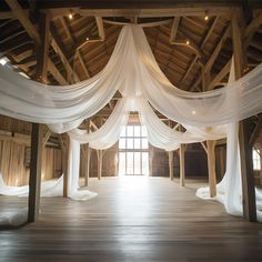 an open room with white drapes and wood floors