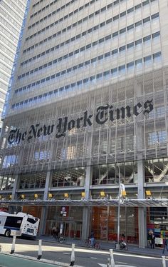 the new york times building is reflected in its glass facade