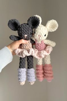 two crocheted stuffed animals are being held by someone's hand in the air