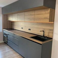 an empty kitchen with wooden counter tops and stainless steel appliances