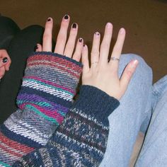 a woman with her hands on the back of her leg wearing striped sweater and black hat