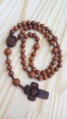 +. This is an wooden rosary. +. I carved an Crucifix and Medal in wood with great delicacy. +. The Crucifix is elaborately engraved on face of Jesus. +. The Medal of the Virgin Mary was also carved exquisitely. +. The rosaries are all made of wood. So, if you touch it with your hands, the wood will have a natural polish. +. +. +. Material +. +. +. Crucifix & Medal : surinam ebony beads : jujube tree +. +. +. Size +. +. +. Crucifix : 31mm(width) * 46mm(height) Beads :10mm&13mm +. Carved c Brown Wooden Beaded Cross Rosary, Brown Cross-shaped Rosary With Wooden Beads, Meditation Rosary With Wooden Beads And Cross Shape, Brown Rosary With 8mm Beads, Wooden Beads Rosary With Crucifix As Gift, Gift Rosary With Wooden Beads And Crucifix, Brown Rosary With 8mm Beads And Cross Shape, Jujube Tree, Knotted Rosary