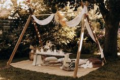 an outdoor picnic area with a table, chairs and hammock in the grass