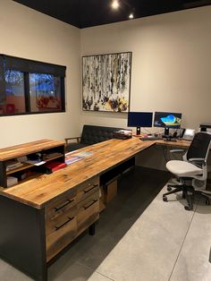 an office with two desks and three monitors