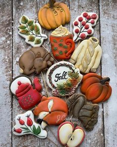 an assortment of decorated cookies sitting on top of a wooden table