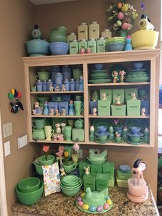 a shelf filled with lots of green dishes