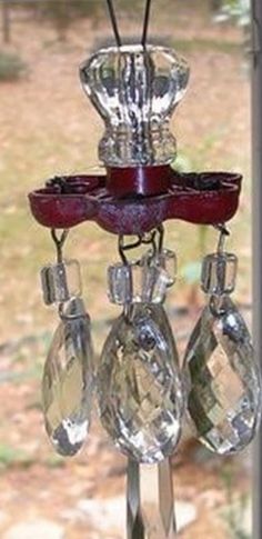 a bird feeder hanging from the side of a window sill with three wine glasses on it