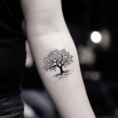 a woman's arm with a tree tattoo on it