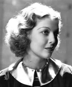 an old black and white photo of a woman wearing a collared shirt with short hair