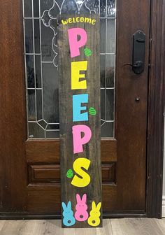 a wooden sign that says welcome peeps on the side of a door with bunny ears