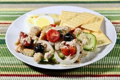 a white plate topped with salad and crackers