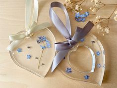 two heart shaped plates with blue flowers and ribbons tied around the edges on a table