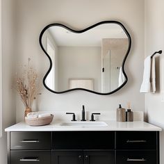 a bathroom vanity with a large mirror above it