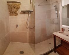 two pictures of a bathroom with shower and sink, one in the process of remodeling