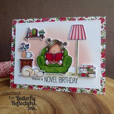 a handmade card with a girl reading a book on a couch and a lamp in the background