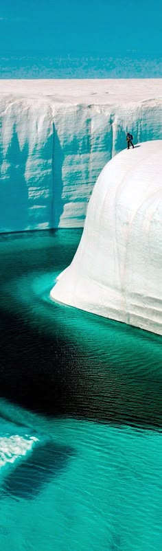 two people are standing on an iceberg in the water