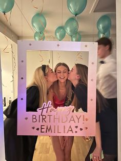 three women kissing each other in front of a birthday photo frame