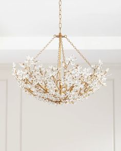 a chandelier with white flowers hanging from the ceiling