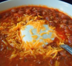 a white bowl filled with chili and cheese