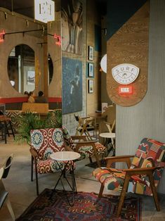 several chairs and tables in a room with pictures on the wall