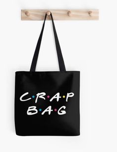 a black tote bag with the words crap bag on it hanging from a wooden hanger