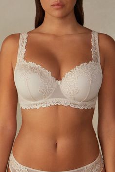 Sofia balconette bra with lightly padded cups and snug underwire that embraces and supports the bust. It is made with an elegant and refined lace available in either two-tone or tone-on-tone options. The underband is lined in tulle to ensure greater hold to the body. The straps are adjustable in back. The underband in larger sizes is wider and a support comes inserted in the cup to better hug and support the bust. It is a design that provides optimal support and emphasizes the décolleté, roundin Elegant Full Coverage Bra With Lace Trim, Classic Full Cup Bra With Removable Cups, Elegant Underbust Bra With Padded Cups, Elegant Underbust Padded Bra, Beige Full Cup Bra With Removable Cups, Elegant Fitted Bra With Medium Bust Support, Elegant Underbust Bra With Removable Pads, Elegant White Bra With Removable Cups, Elegant Full Cup Bra