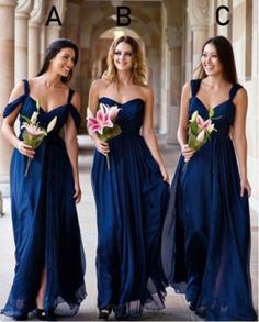 three beautiful women in blue dresses posing for the camera with one holding a flower bouquet